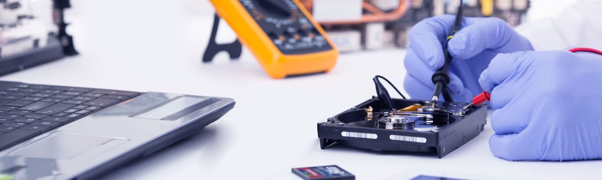 Technician repairing a hard drive at the workbench